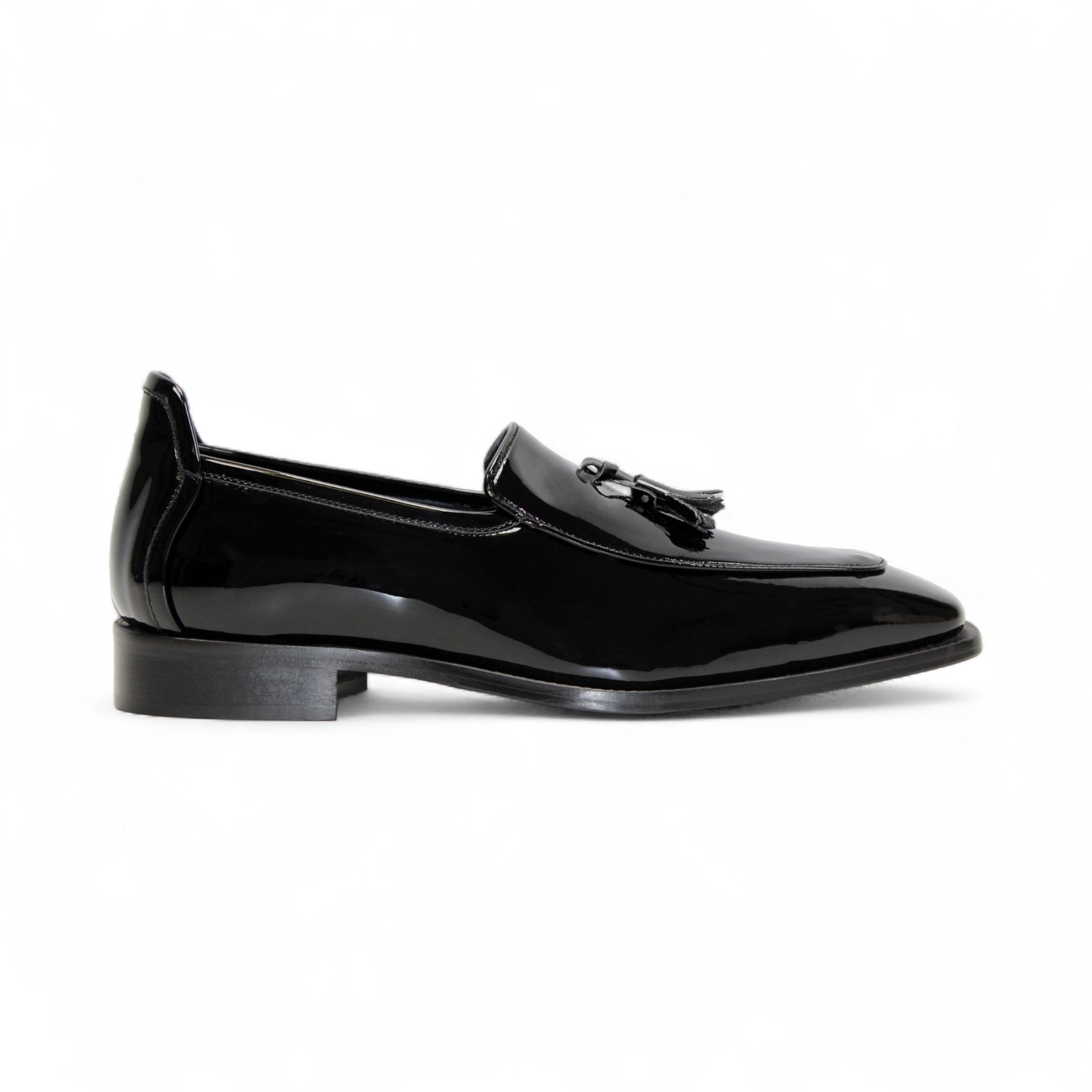 The Duca Di Matiste Duca Fano Black is a sleek black patent leather loafer with a tassel detail and low heel, made in Italy—offering minimalist luxury and timeless style on a white background.