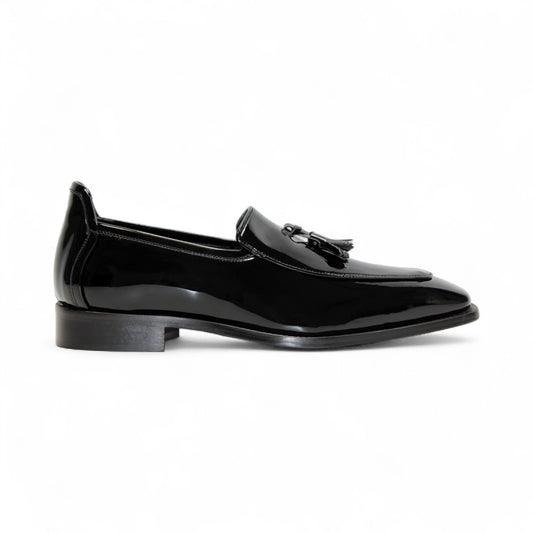 The Duca Di Matiste Duca Fano Black is a sleek black patent leather loafer with a tassel detail and low heel, made in Italy—offering minimalist luxury and timeless style on a white background.
