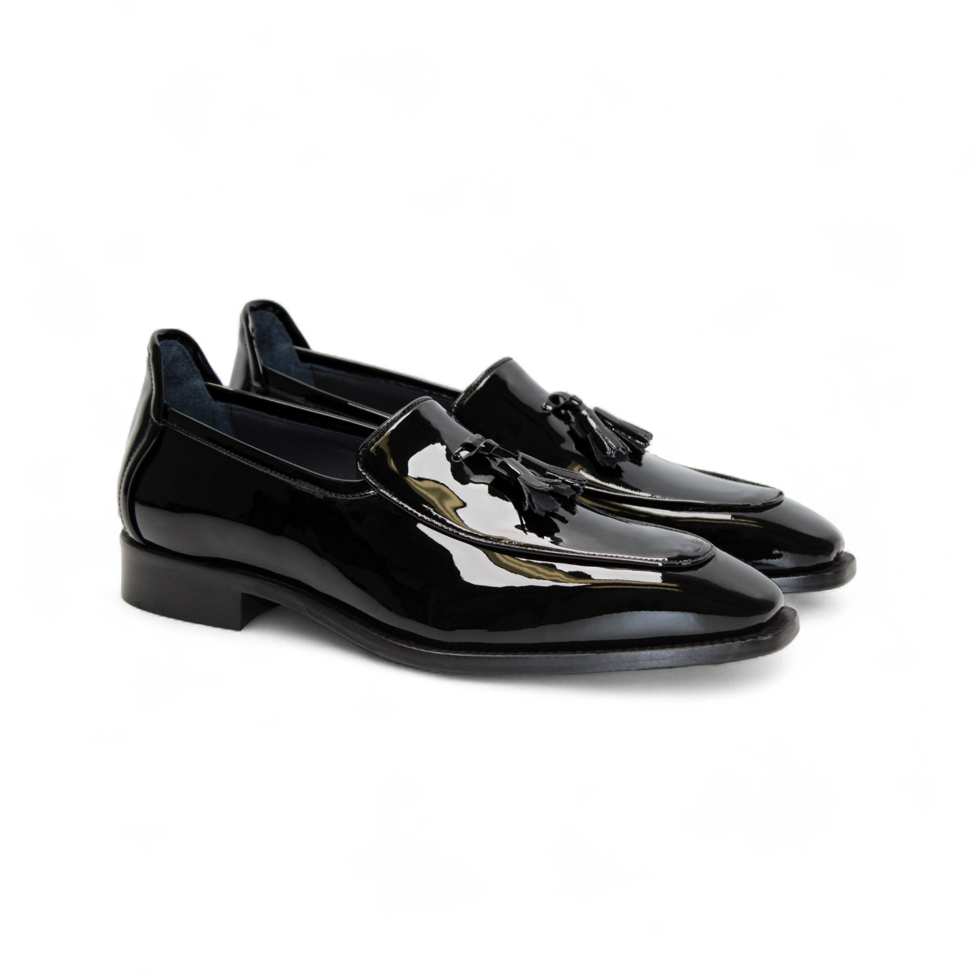 The Duca Di Matiste Duca Fano Black is a sleek black patent leather loafer with a tassel detail and low heel, made in Italy—offering minimalist luxury and timeless style on a white background.
