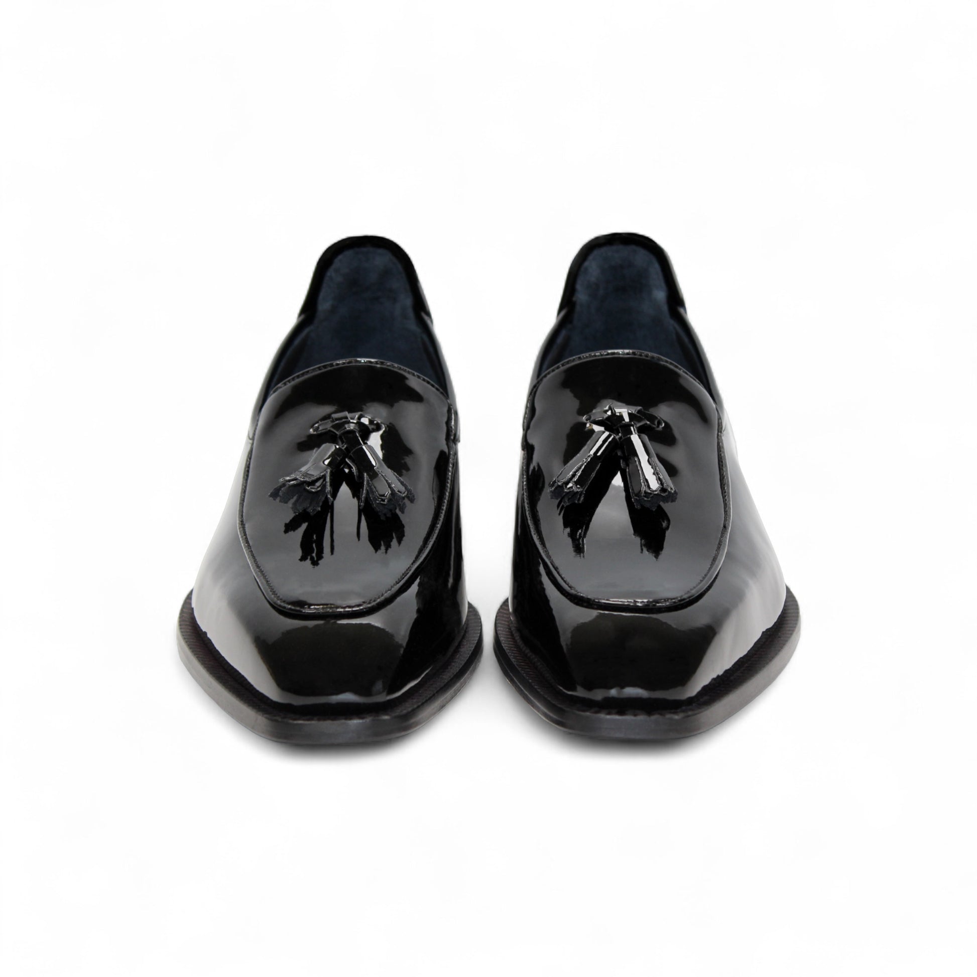The Duca Di Matiste Duca Fano Black is a sleek black patent leather loafer with a tassel detail and low heel, made in Italy—offering minimalist luxury and timeless style on a white background.