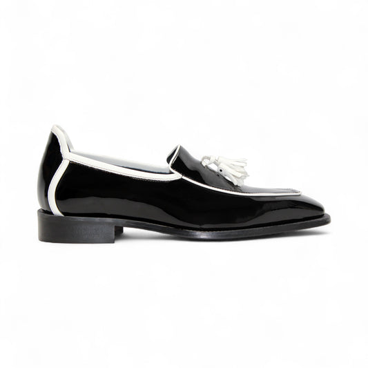 The Duca Di Matiste Duca Fano Black/White is a black patent leather loafer with white trim and tassel detail, shown in profile against a plain white background—an elegant luxury men’s footwear choice.