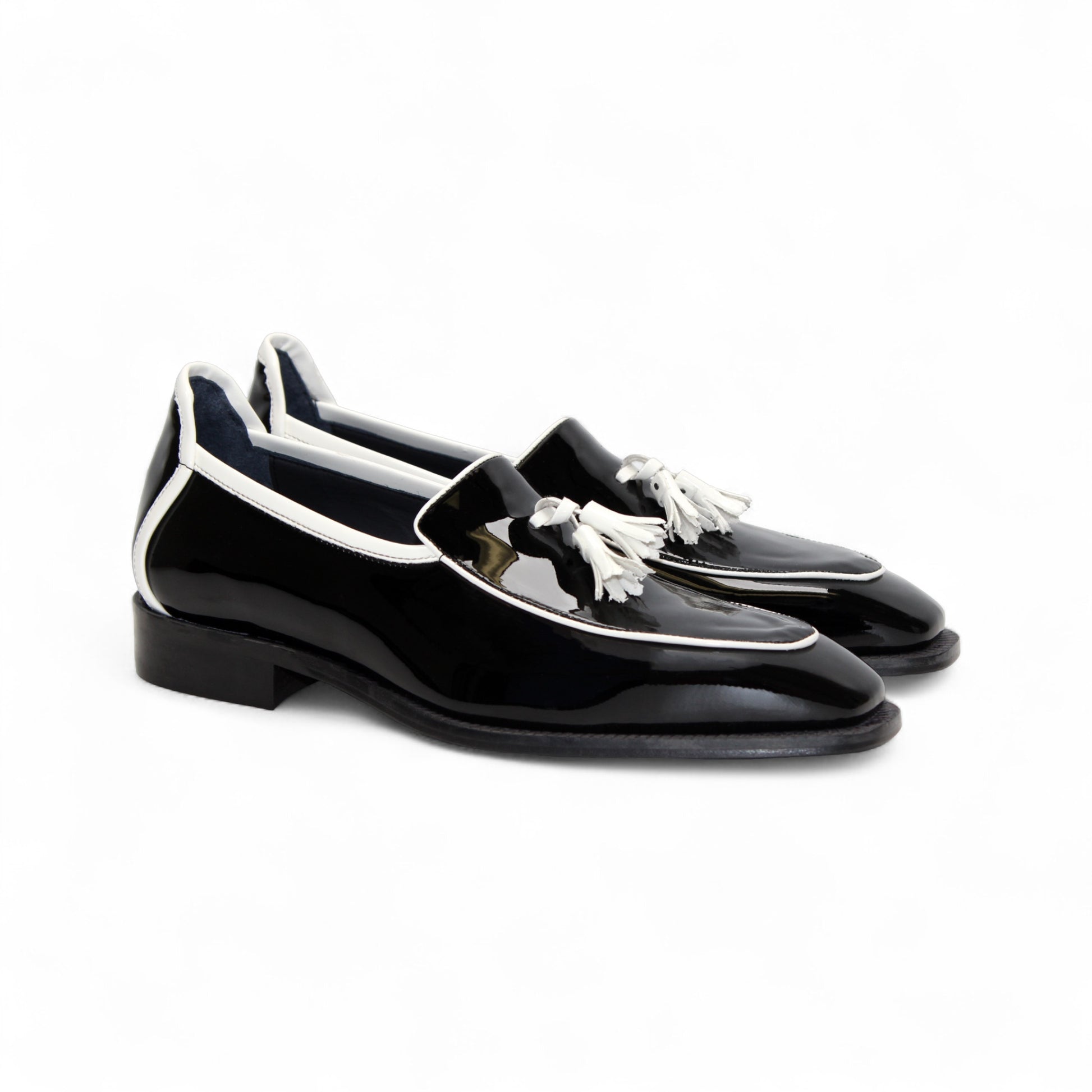The Duca Di Matiste Duca Fano Black/White is a black patent leather loafer with white trim and tassel detail, shown in profile against a plain white background—an elegant luxury men’s footwear choice.