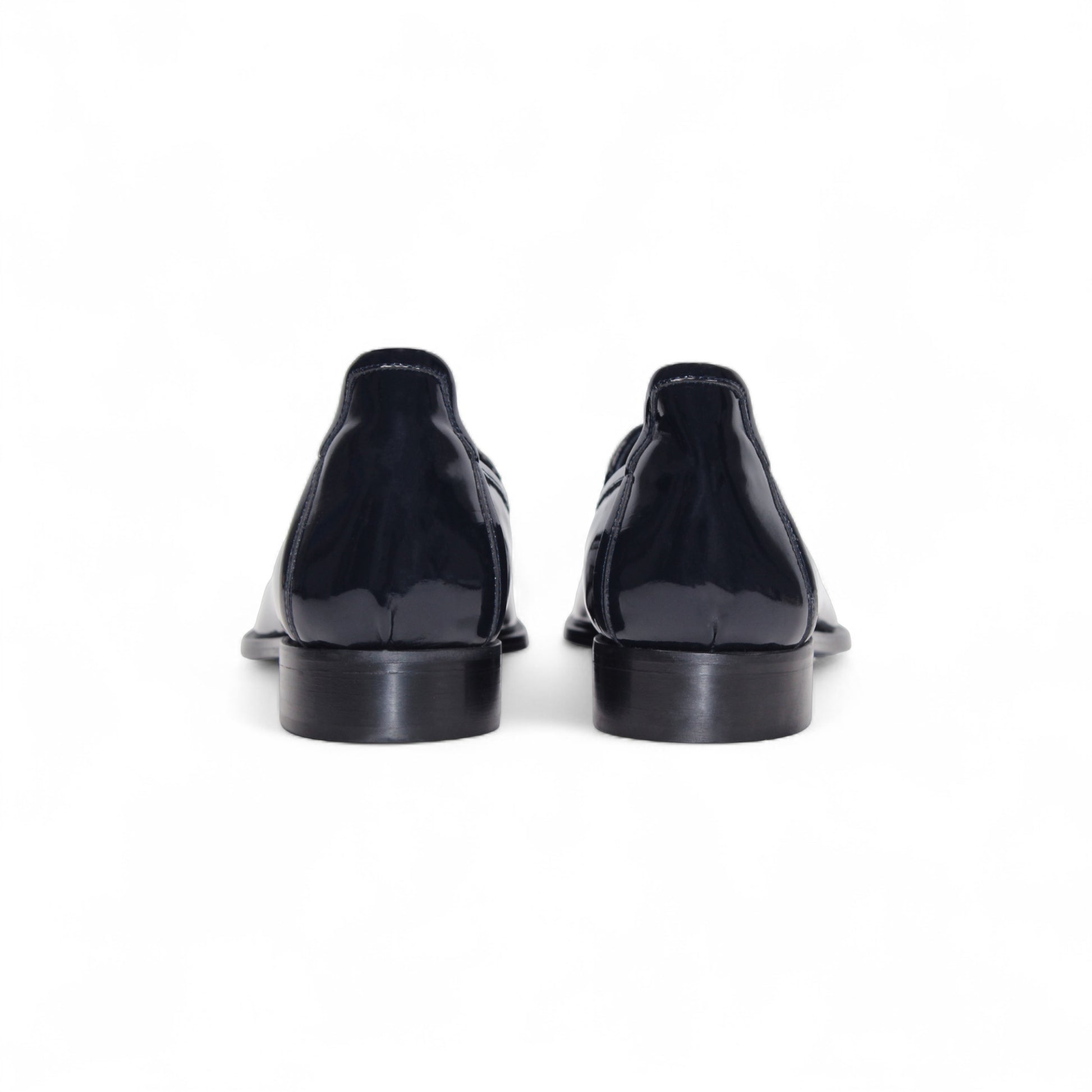 The Duca Di Matiste Duca Fano Navy loafer, featuring a tassel detail, low stacked heel, and almond toe in navy leather, showcases minimalist elegance in a side profile against a white background.