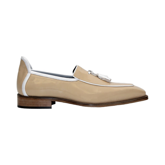 The Duca Di Matiste Duca Fano Cream/White loafer features beige patent leather, white trim, a wooden heel, and decorative tassels. This minimalist, elegant shoe is beautifully crafted in Italy. Shown in profile view.
