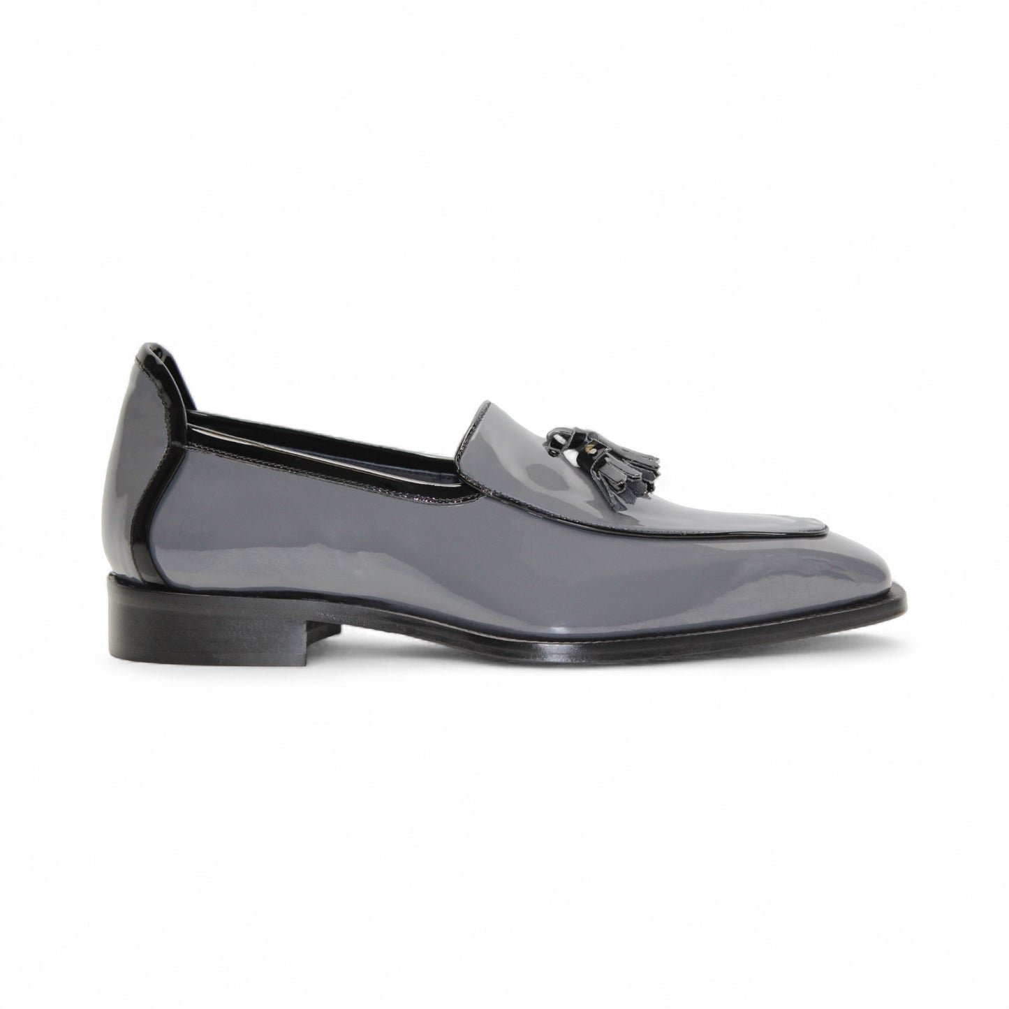 The Duca Di Matiste Duca Fano Grey/Black is an Italian-crafted glossy patent leather loafer with front tassel detail, low black heel, and black sole—showcasing minimalist luxury from every angle.
