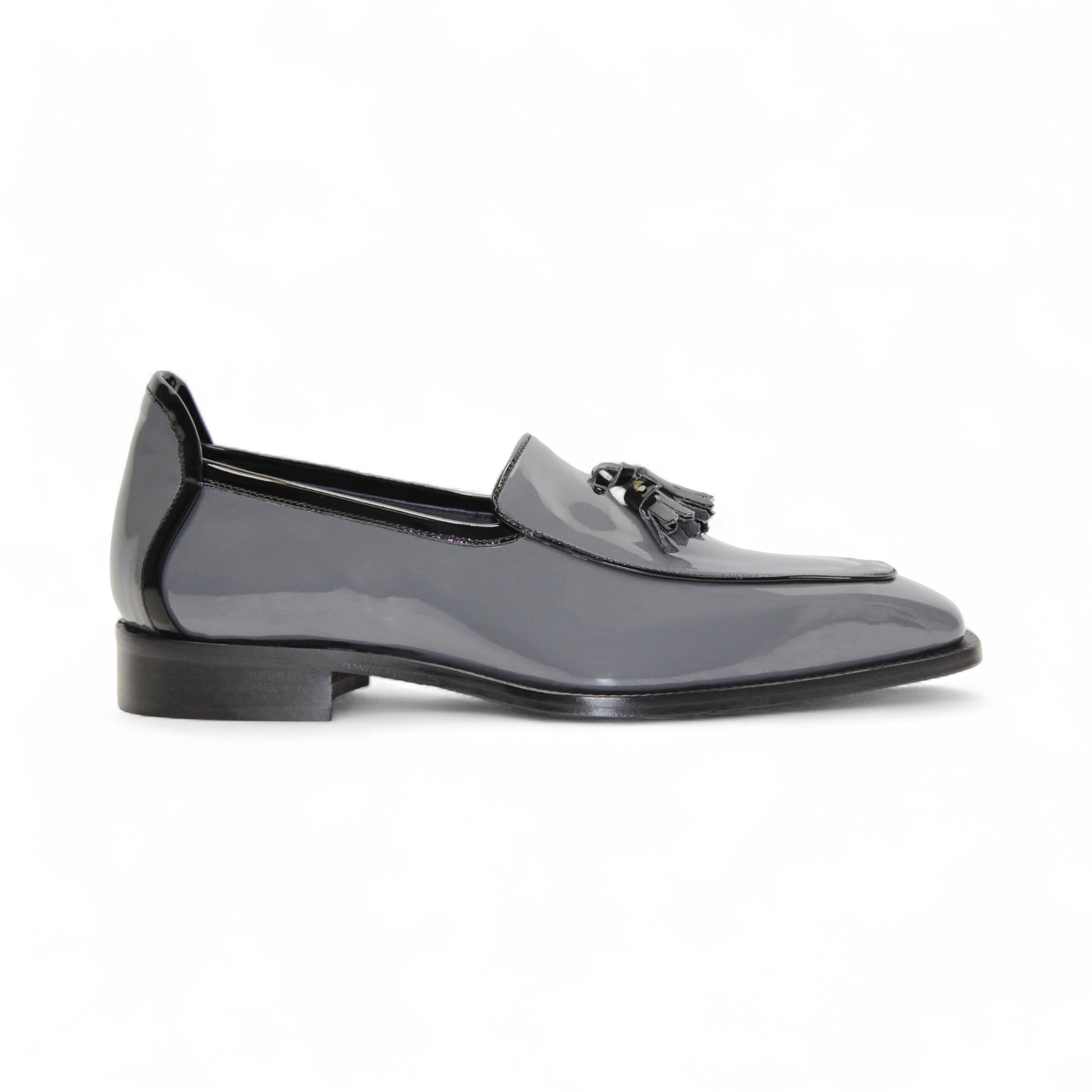 The Duca Di Matiste Duca Fano Grey/Black is an Italian-crafted glossy patent leather loafer with front tassel detail, low black heel, and black sole—showcasing minimalist luxury from every angle.