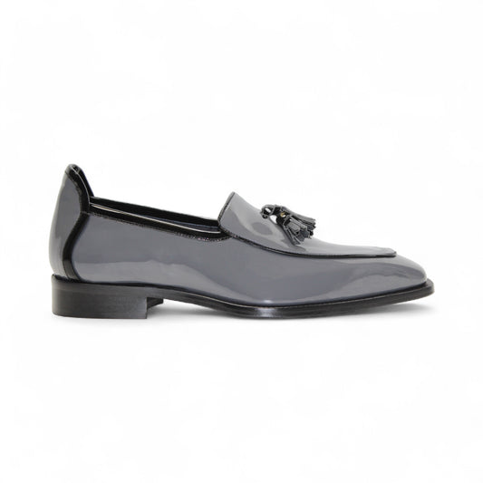 The Duca Di Matiste Duca Fano Grey/Black is an Italian-crafted glossy patent leather loafer with front tassel detail, low black heel, and black sole—showcasing minimalist luxury from every angle.