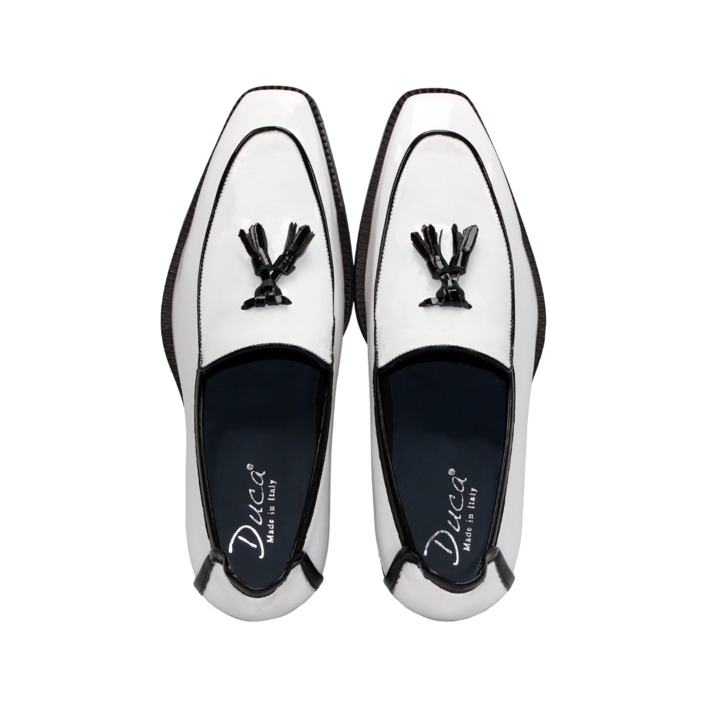The Duca Di Matiste Duca Fano White/Black loafer features white patent leather, black trim, tassel detail, a low heel, and a glossy finish—shown minimalist style on a plain white background.