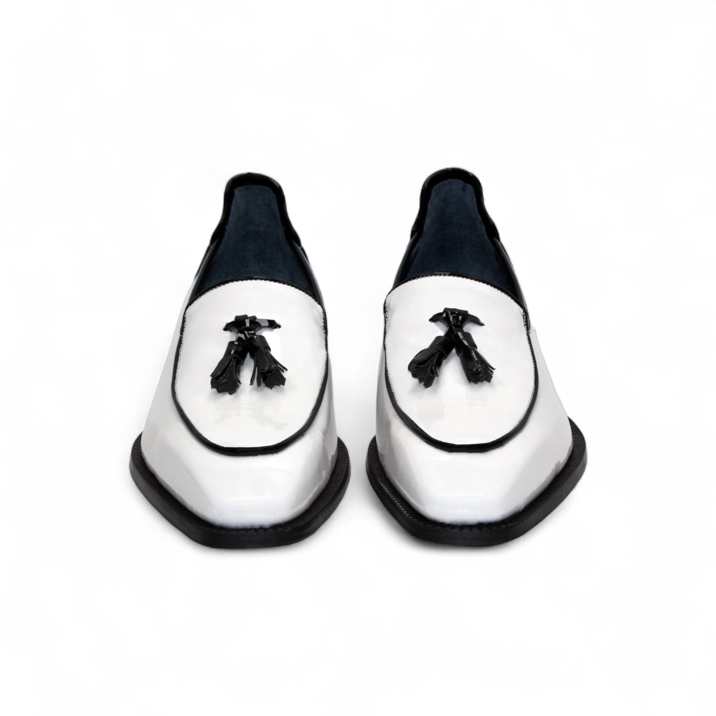 The Duca Di Matiste Duca Fano White/Black loafer features white patent leather, black trim, tassel detail, a low heel, and a glossy finish—shown minimalist style on a plain white background.