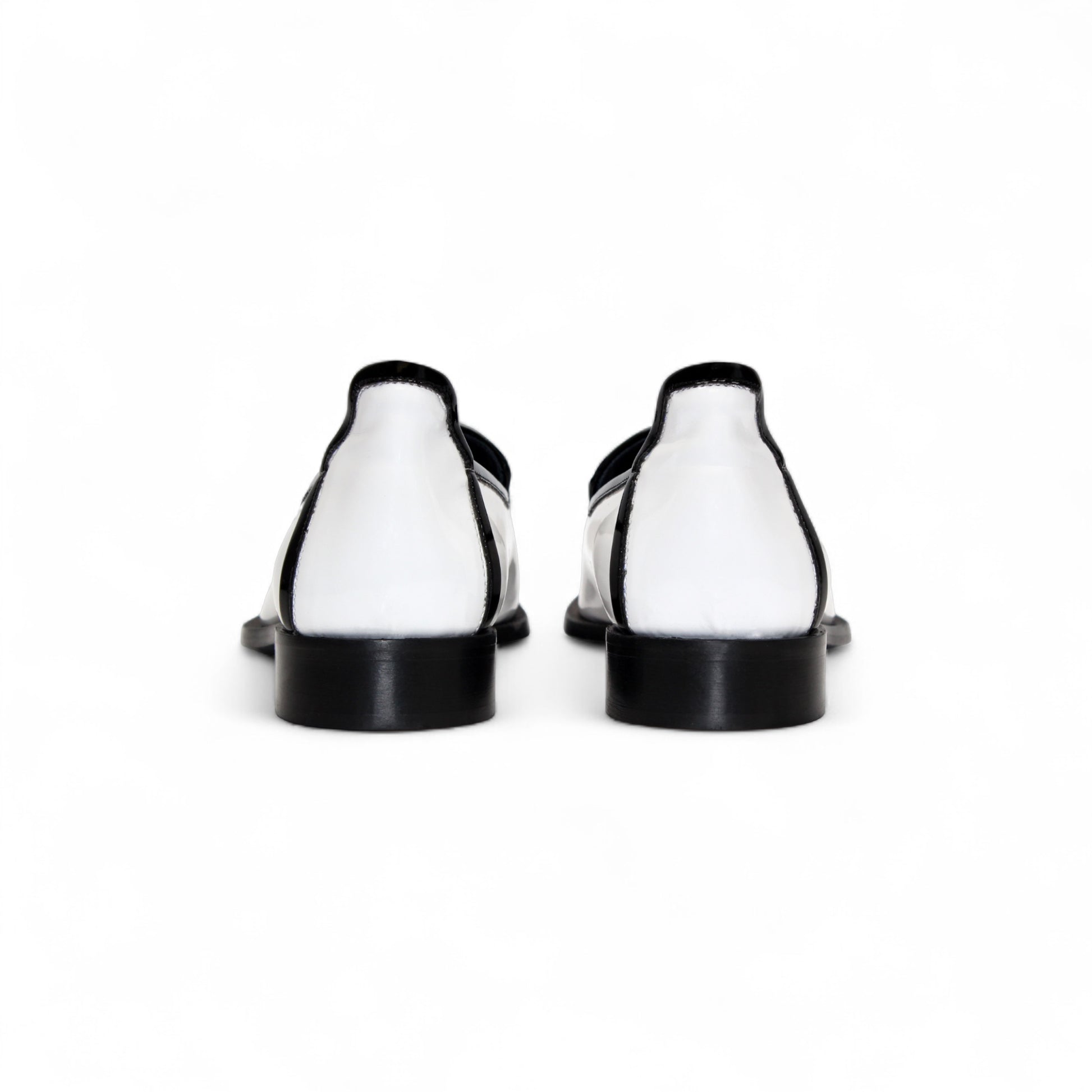 The Duca Di Matiste Duca Fano White/Black loafer features white patent leather, black trim, tassel detail, a low heel, and a glossy finish—shown minimalist style on a plain white background.