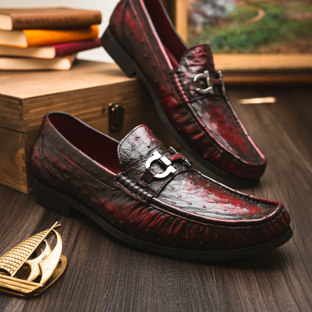 The Marco Di Milano Ferrioni BlackCherry loafers, shown with one upright and one on its side to reveal the sole, feature classic metal bit detailing—ideal for those seeking luxury men's footwear.