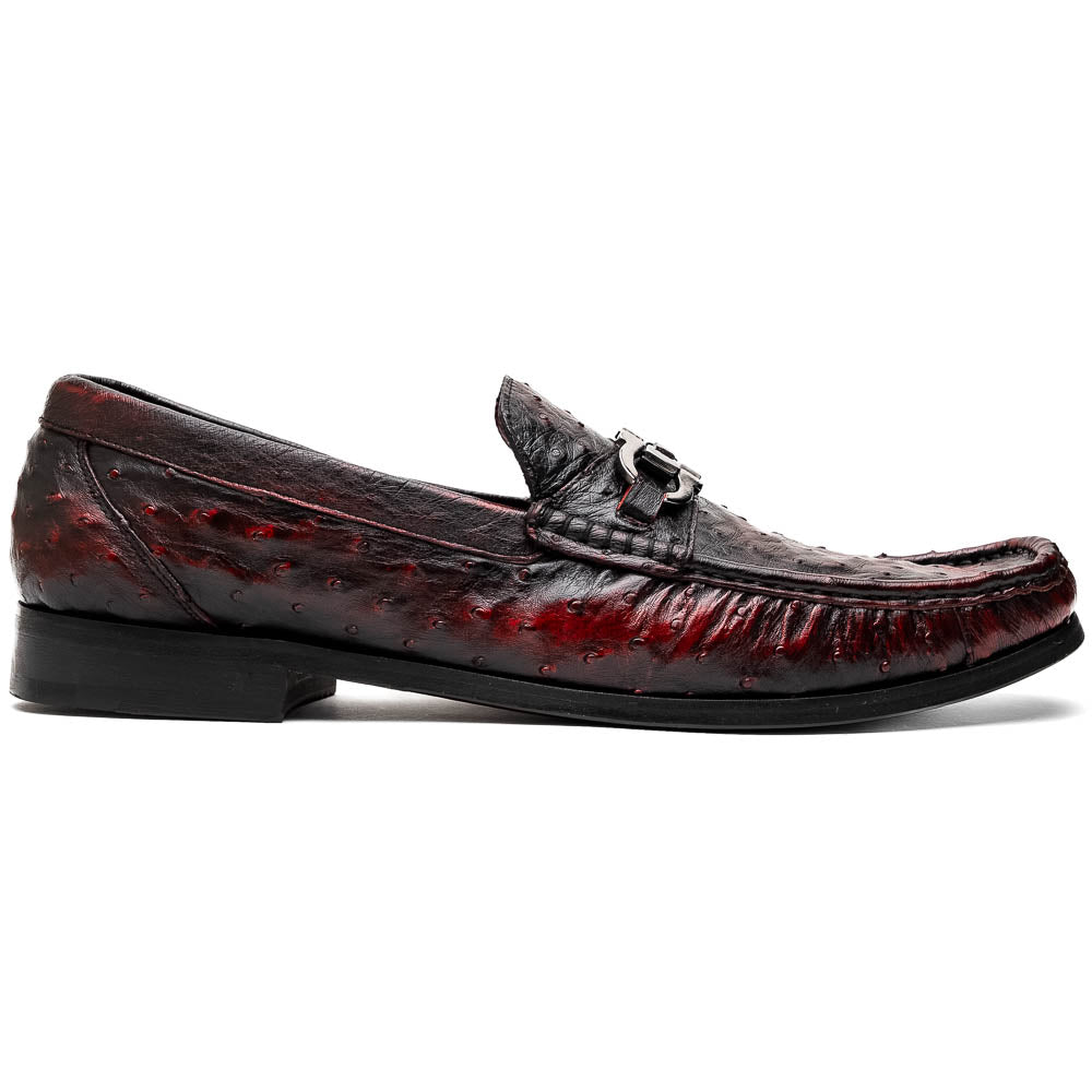 The Marco Di Milano Ferrioni BlackCherry loafers, shown with one upright and one on its side to reveal the sole, feature classic metal bit detailing—ideal for those seeking luxury men's footwear.
