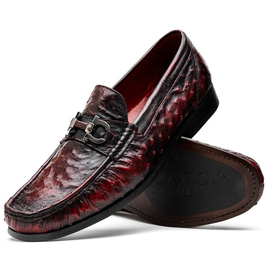 The Marco Di Milano Ferrioni BlackCherry loafers, shown with one upright and one on its side to reveal the sole, feature classic metal bit detailing—ideal for those seeking luxury men's footwear.
