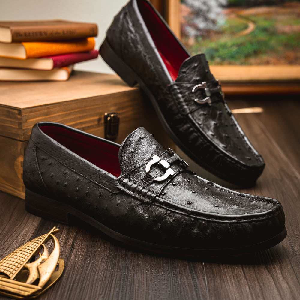 The Marco Di Milano Ferrioni Black: luxury men's loafers in genuine ostrich leather with metal buckles and brown soles, shown both upright and on their side to highlight the branding.