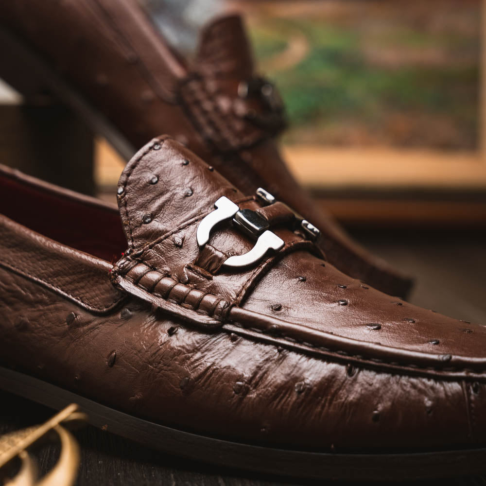 Experience luxury with the Ferrioni Kango Tabac by Marco Di Milano—brown leather men's loafers featuring a textured finish, metal buckle detail, and signature branding on the sole.