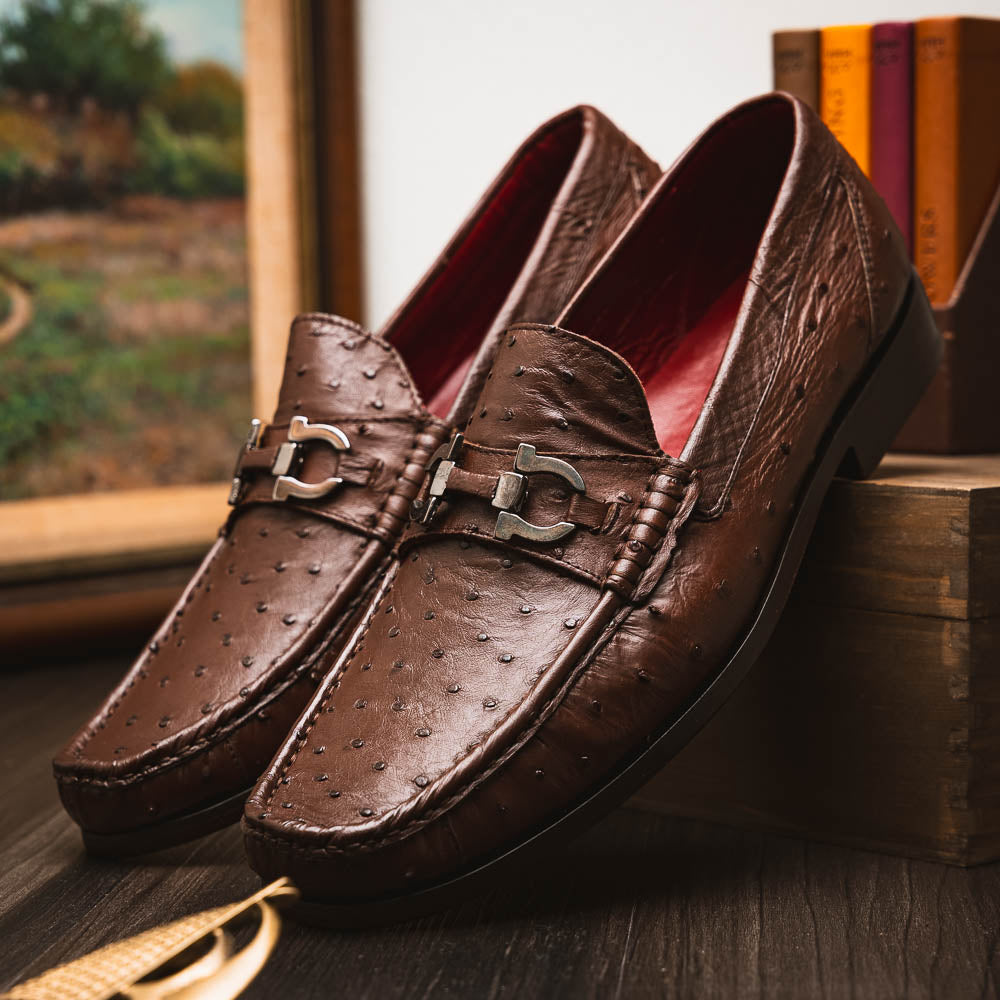 Experience luxury with the Ferrioni Kango Tabac by Marco Di Milano—brown leather men's loafers featuring a textured finish, metal buckle detail, and signature branding on the sole.