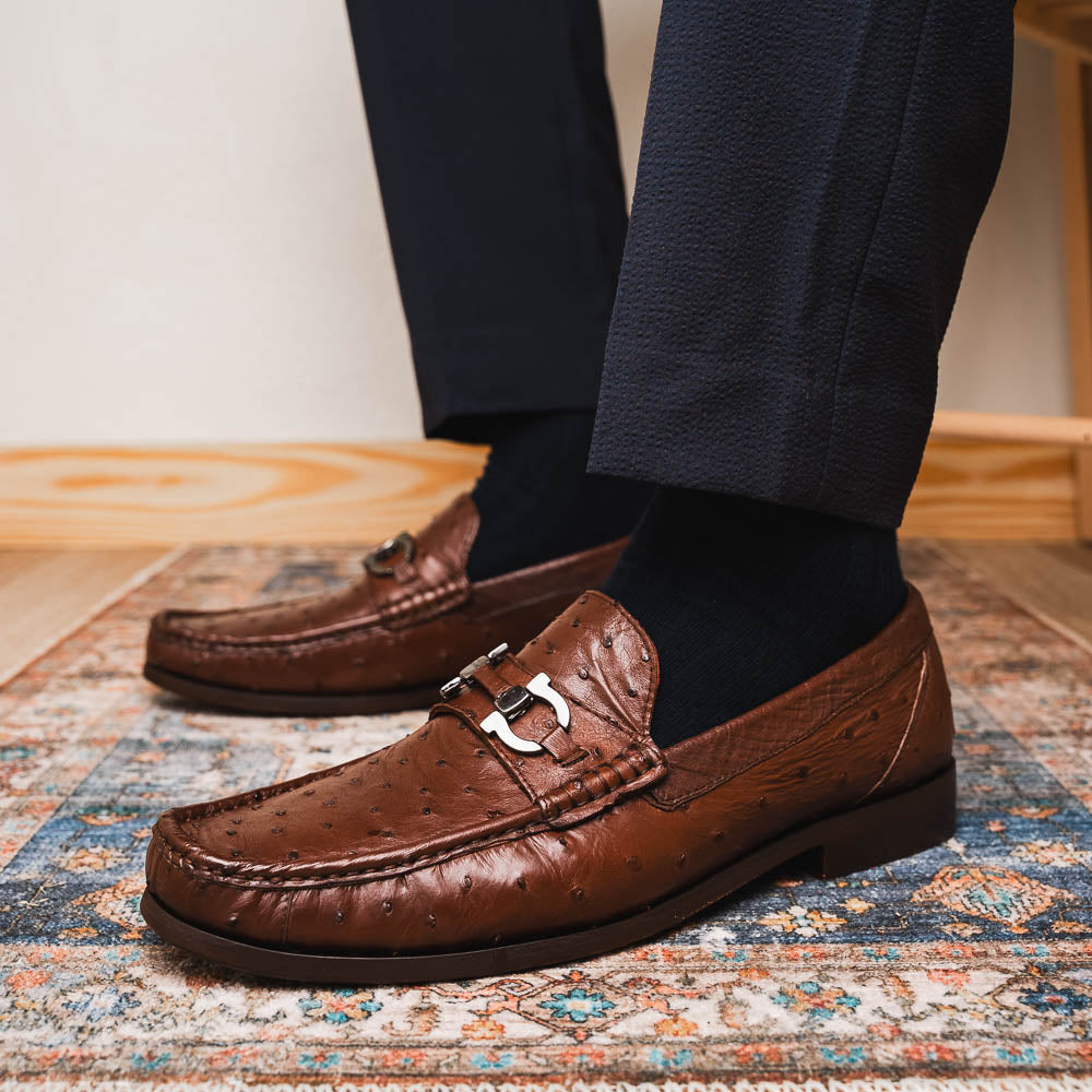 Experience luxury with the Ferrioni Kango Tabac by Marco Di Milano—brown leather men's loafers featuring a textured finish, metal buckle detail, and signature branding on the sole.
