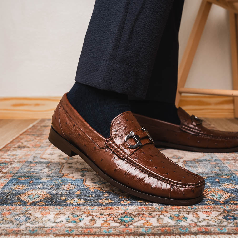 Experience luxury with the Ferrioni Kango Tabac by Marco Di Milano—brown leather men's loafers featuring a textured finish, metal buckle detail, and signature branding on the sole.
