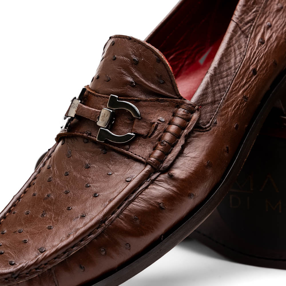 Experience luxury with the Ferrioni Kango Tabac by Marco Di Milano—brown leather men's loafers featuring a textured finish, metal buckle detail, and signature branding on the sole.