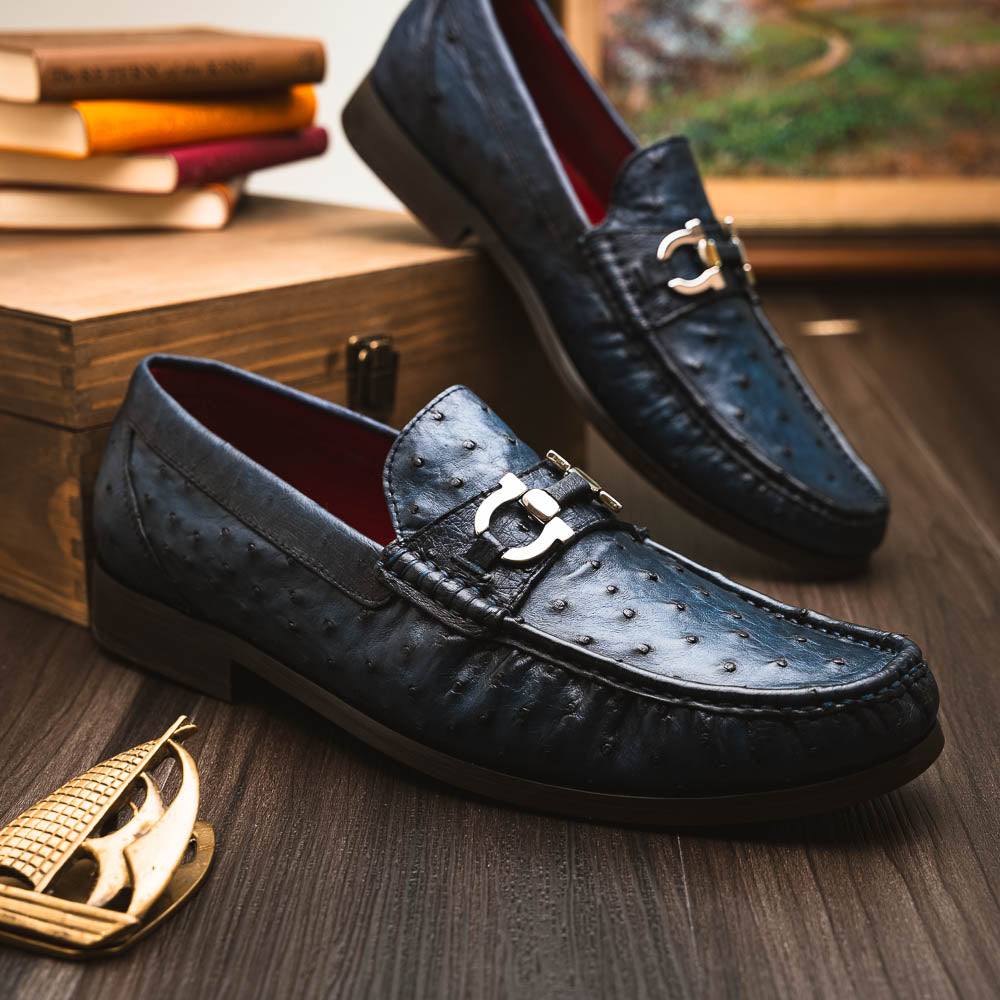 A pair of luxury men's shoes: Ferrioni Navy loafers by Marco Di Milano in genuine ostrich leather, featuring classic bit detail. One shoe is upright, the other shows the sole with "Marco Di Milano" branding.