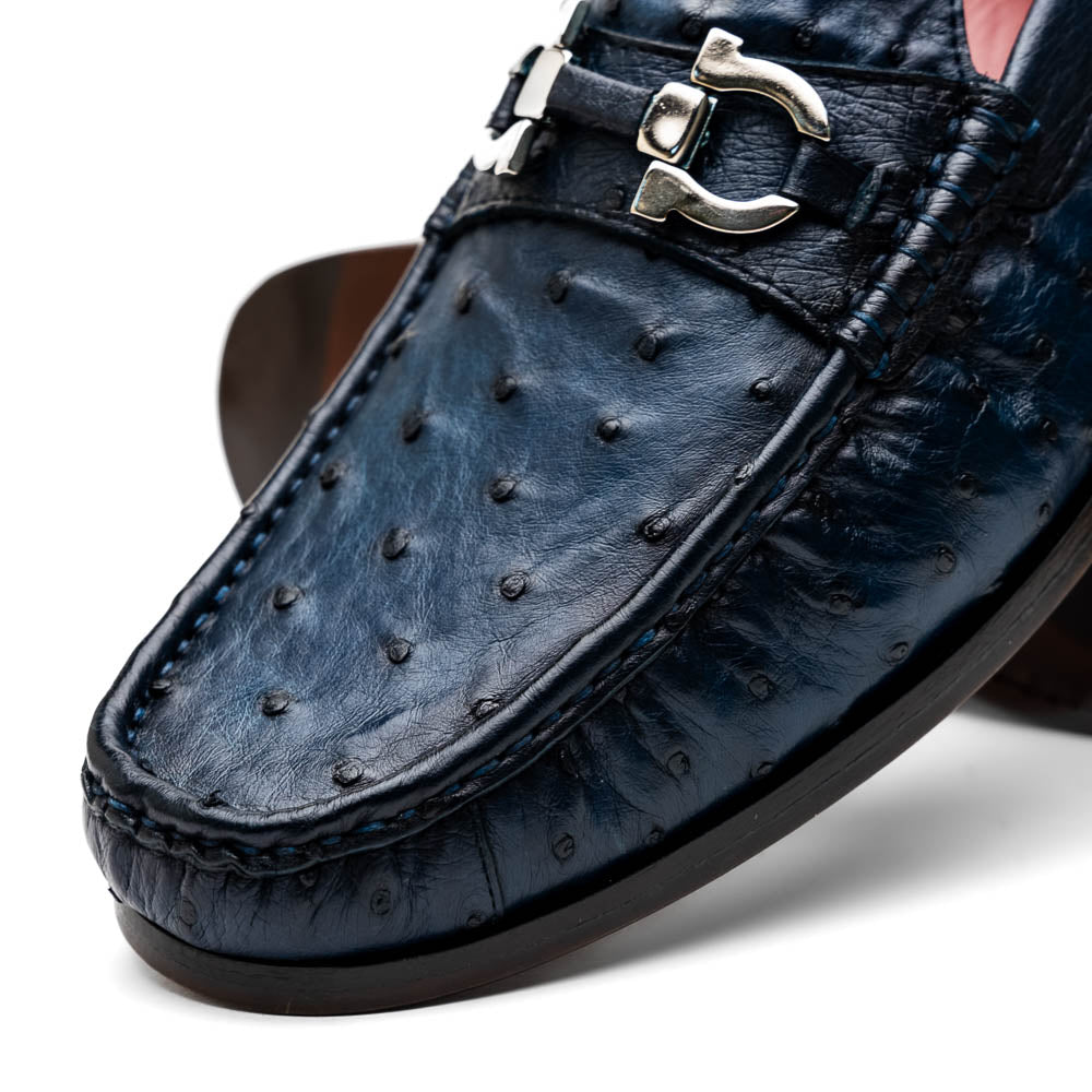 A pair of luxury men's shoes: Ferrioni Navy loafers by Marco Di Milano in genuine ostrich leather, featuring classic bit detail. One shoe is upright, the other shows the sole with "Marco Di Milano" branding.