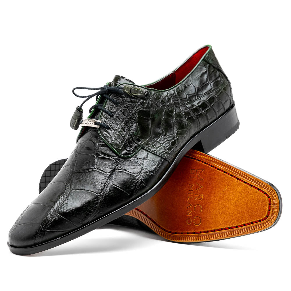 A pair of Fitipaldi Olive luxury footwear by Marco Di Milano in black crocodile leather—one shoe upright, the other showing a tan sole with "Marco Di Milano" embossed—crafted with hand-painted finishes for an elegant touch.