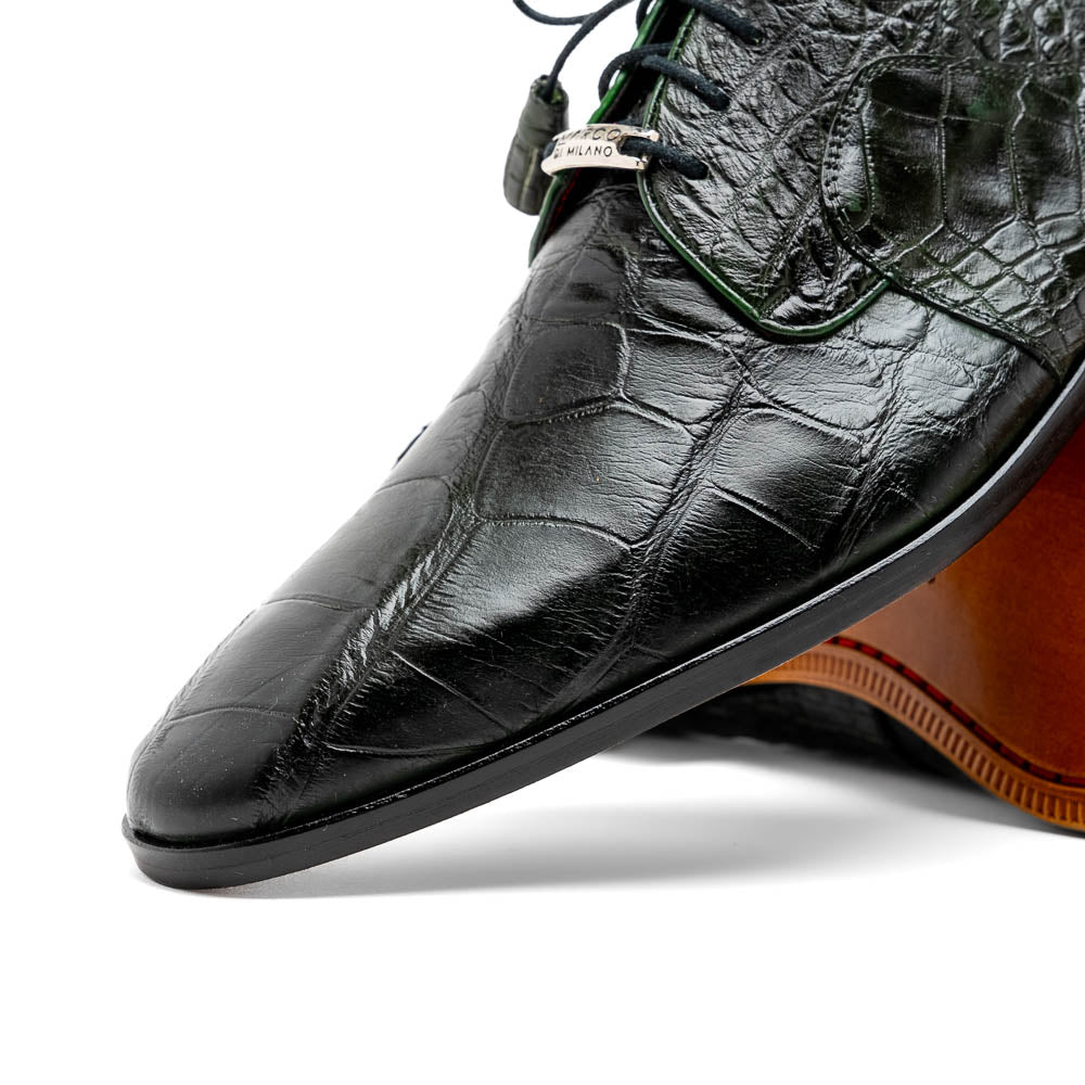 A pair of Fitipaldi Olive luxury footwear by Marco Di Milano in black crocodile leather—one shoe upright, the other showing a tan sole with "Marco Di Milano" embossed—crafted with hand-painted finishes for an elegant touch.