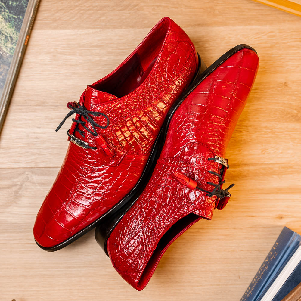 The Marco Di Milano Fitipaldi Red features luxury handmade men's shoes in red crocodile-pattern leather with black laces and brown soles—one shoe upright, the other propped beneath.