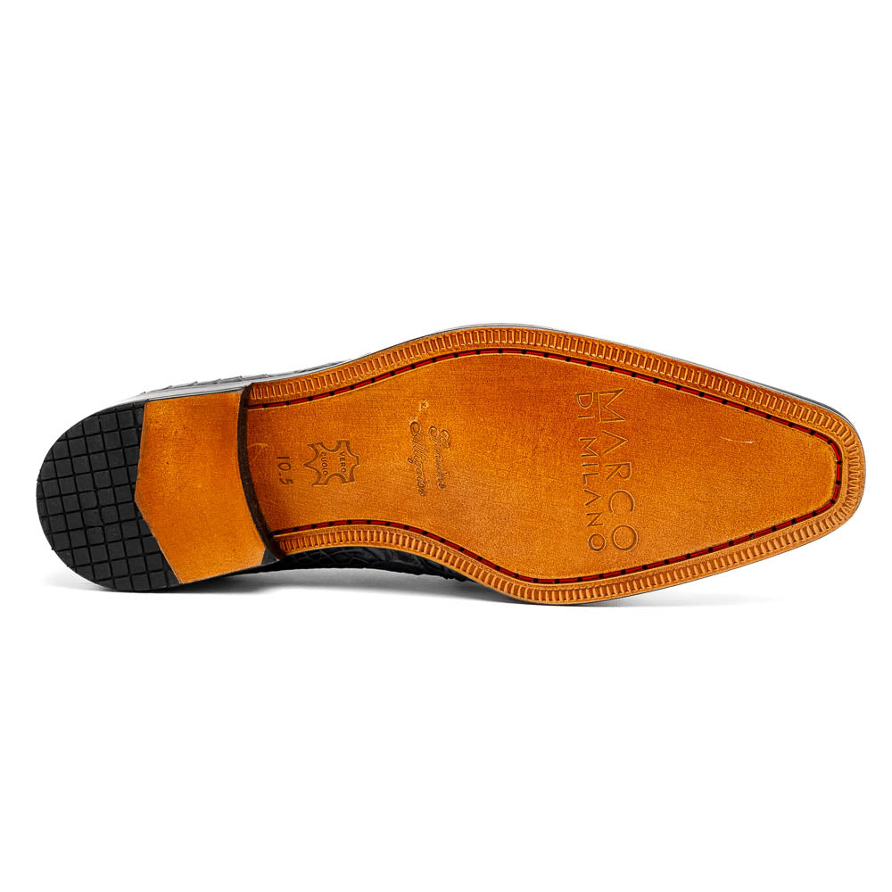 A pair of gray crocodile-pattern luxury dress shoes, the Fitipaldi Rustic Gray by Marco Di Milano, are shown—one upright and one on its side—to display a tan sole marked "Marco Di Milano." Hand-painted finishes showcase exquisite craftsmanship.