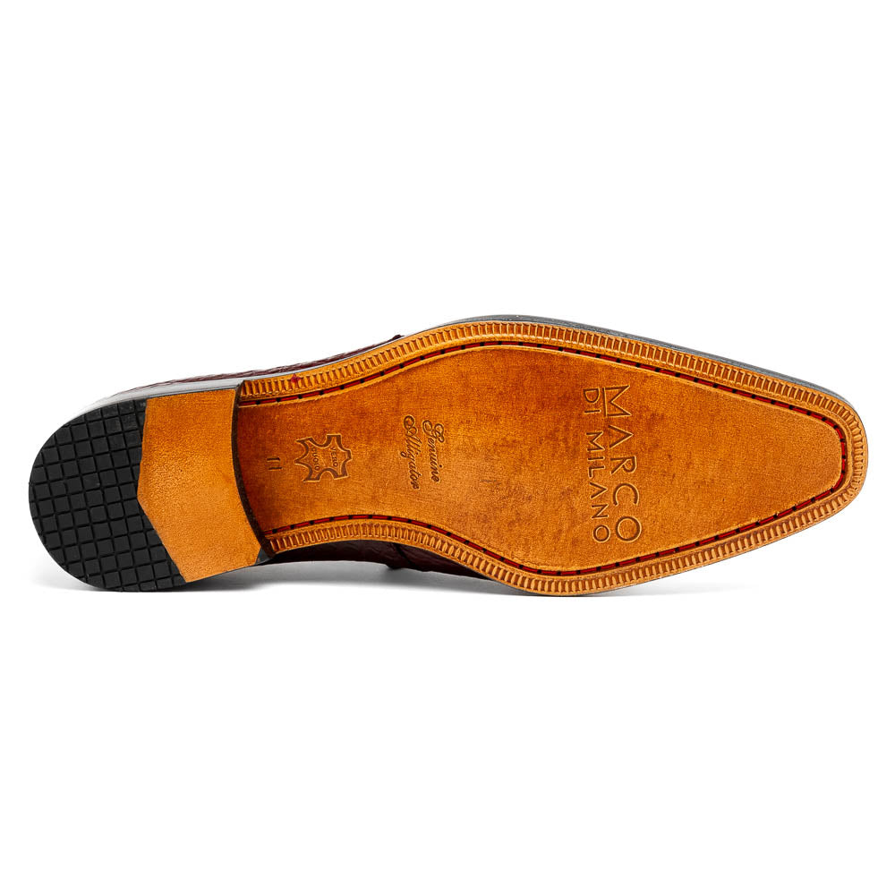 The Fitipaldi Wine by Marco Di Milano is a burgundy crocodile-pattern leather dress shoe with black laces, shown on its side to reveal the tan sole and logo—highlighting hand-painted details and luxury craftsmanship.
