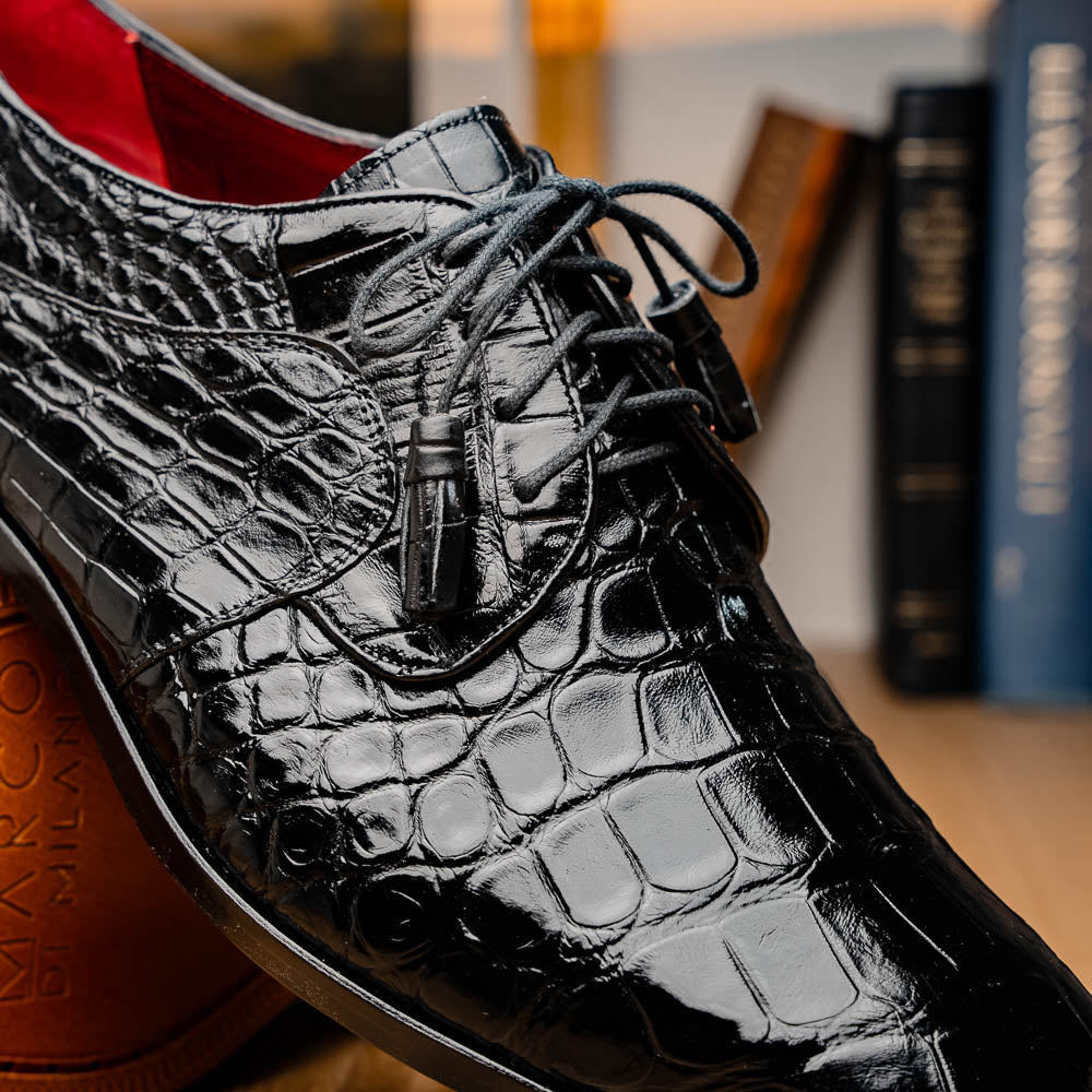 The Fitipaldi Black by Marco Di Milano: luxury black crocodile-patterned leather dress shoes with laces, one upright and one sole up to reveal a hand-painted orange-brown sole.