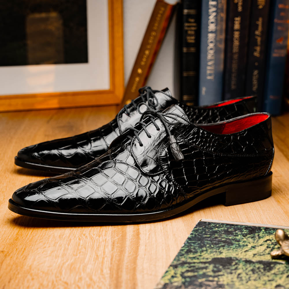 The Fitipaldi Black by Marco Di Milano: luxury black crocodile-patterned leather dress shoes with laces, one upright and one sole up to reveal a hand-painted orange-brown sole.