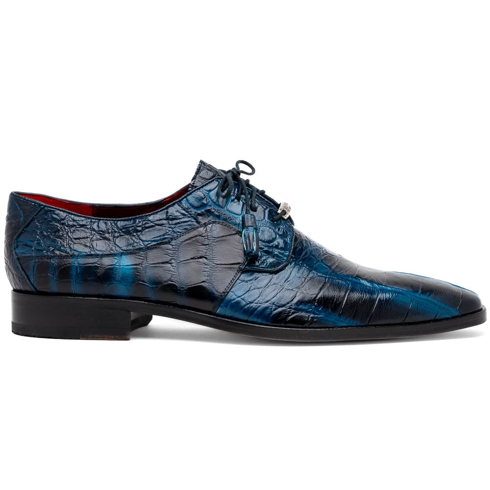 Fitipaldi Rustic Navy by Marco Di Milano: a pair of blue leather men’s dress shoes with a crocodile pattern, black soles, and lace-up fronts; one luxury shoe is shown on its side to display the tan sole.