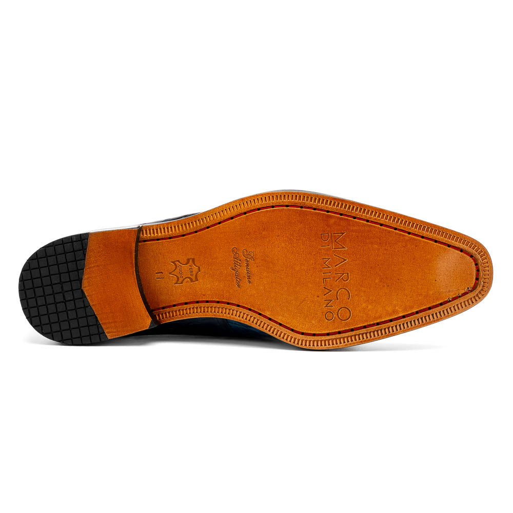 Fitipaldi Rustic Navy by Marco Di Milano: a pair of blue leather men’s dress shoes with a crocodile pattern, black soles, and lace-up fronts; one luxury shoe is shown on its side to display the tan sole.