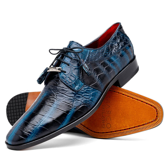Fitipaldi Rustic Navy by Marco Di Milano: a pair of blue leather men’s dress shoes with a crocodile pattern, black soles, and lace-up fronts; one luxury shoe is shown on its side to display the tan sole.