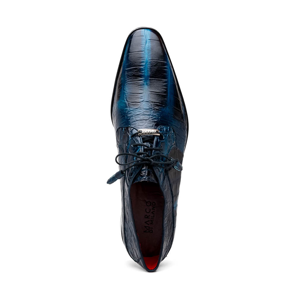 Fitipaldi Rustic Navy by Marco Di Milano: a pair of blue leather men’s dress shoes with a crocodile pattern, black soles, and lace-up fronts; one luxury shoe is shown on its side to display the tan sole.
