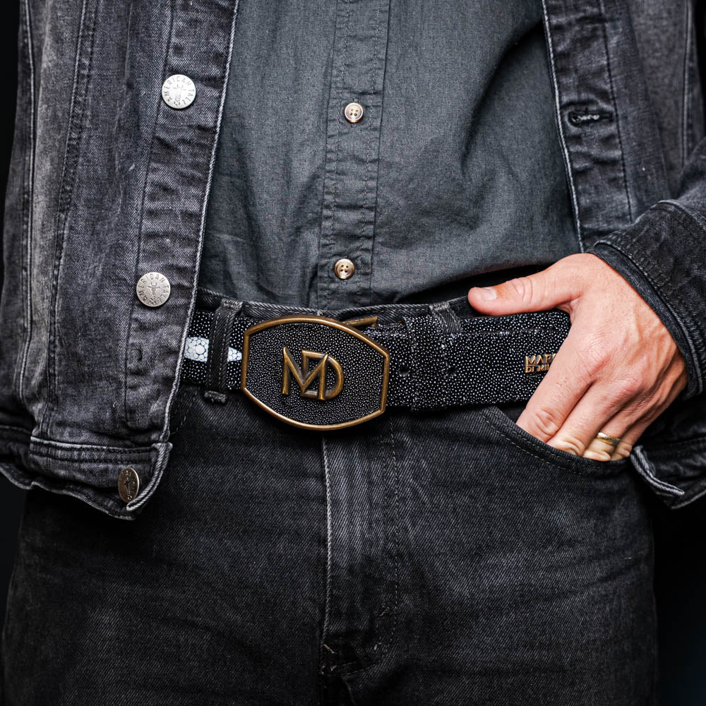 The Georgia Belt Black by Marco Di Milano is a luxury men's belt made from genuine stingray skin, featuring a bold black texture and a large gold "MD" buckle.