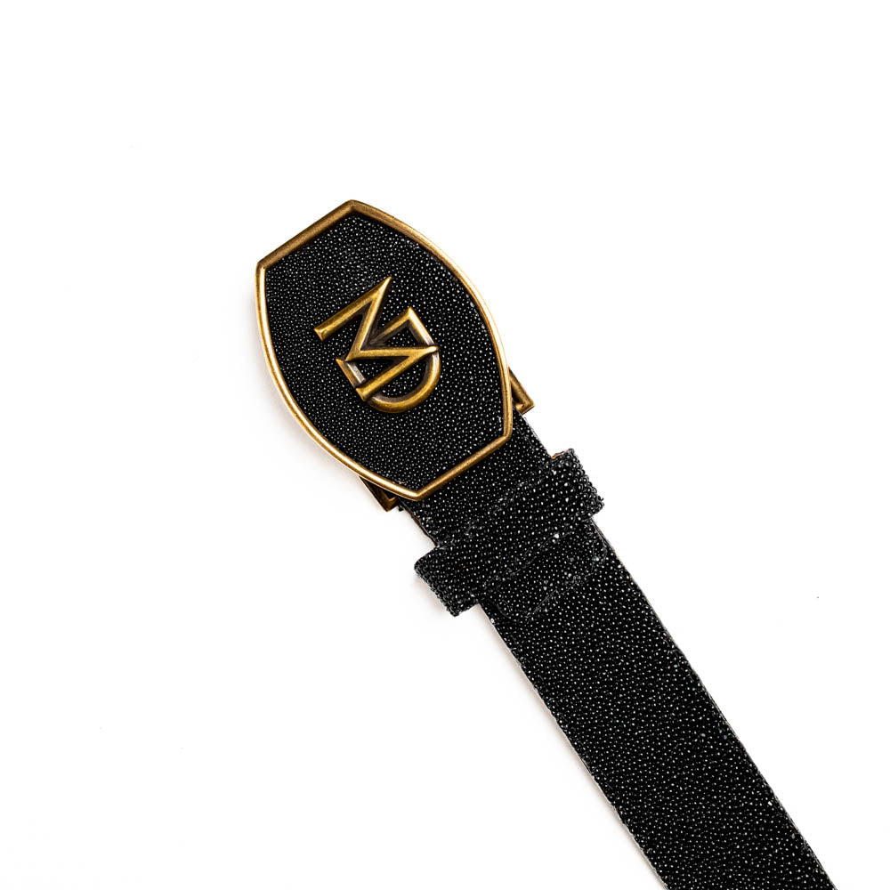 The Georgia Belt Black by Marco Di Milano is a luxury men's belt made from genuine stingray skin, featuring a bold black texture and a large gold "MD" buckle.