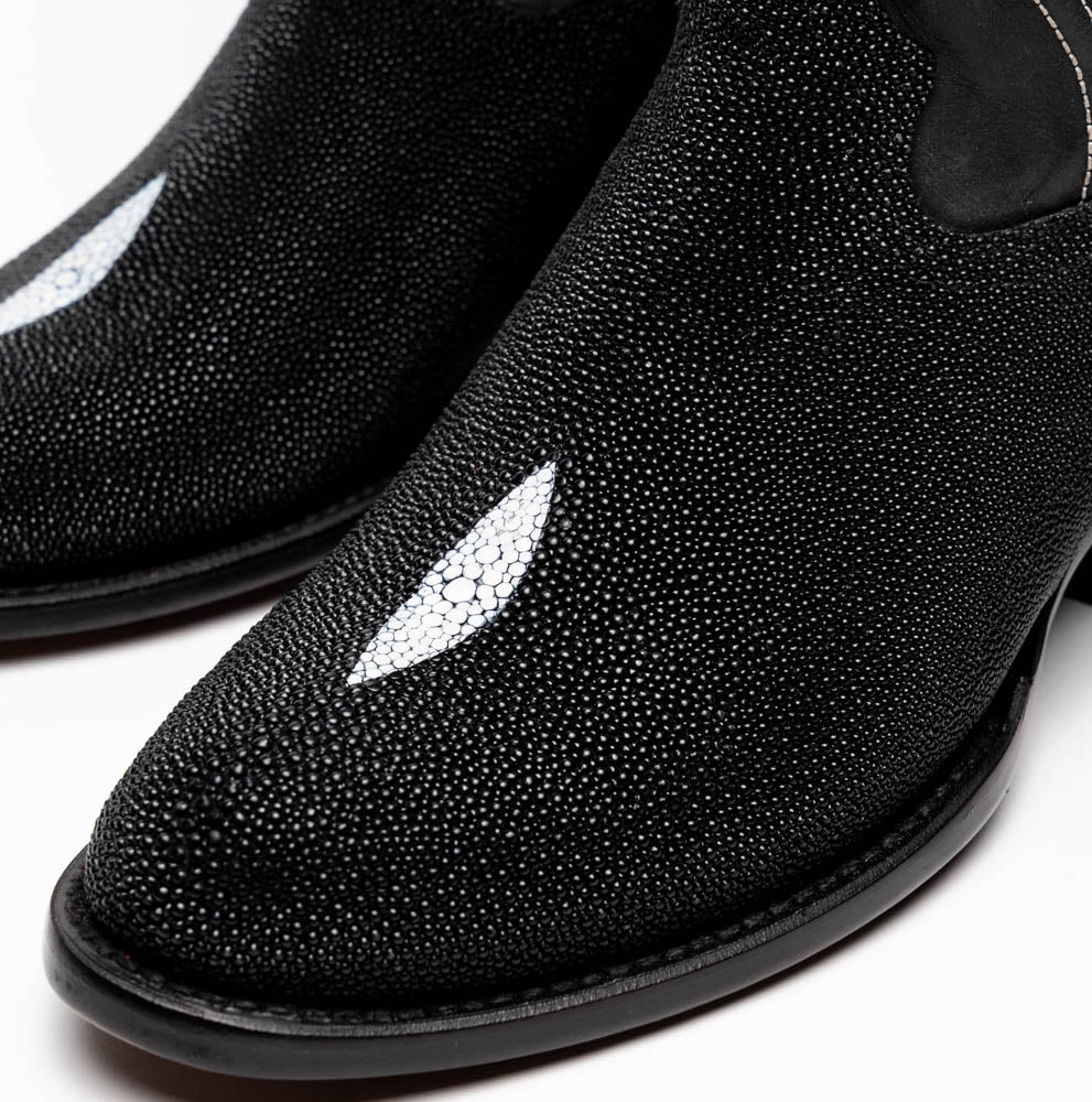 A pair of Georgia Black handcrafted western boots by Marco Di Milano, featuring white stitching—one boot upright and the other on its side displaying the branded sole.