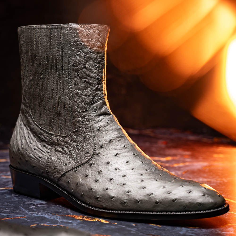 The Giorgio Serpentine Gray boots by Marco Di Milano—crafted from genuine ostrich quill leather—feature one upright and one on its side to reveal the sole, highlighting luxurious materials and exceptional craftsmanship.