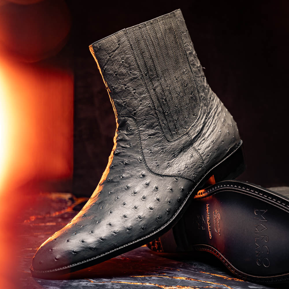 The Giorgio Serpentine Gray boots by Marco Di Milano—crafted from genuine ostrich quill leather—feature one upright and one on its side to reveal the sole, highlighting luxurious materials and exceptional craftsmanship.
