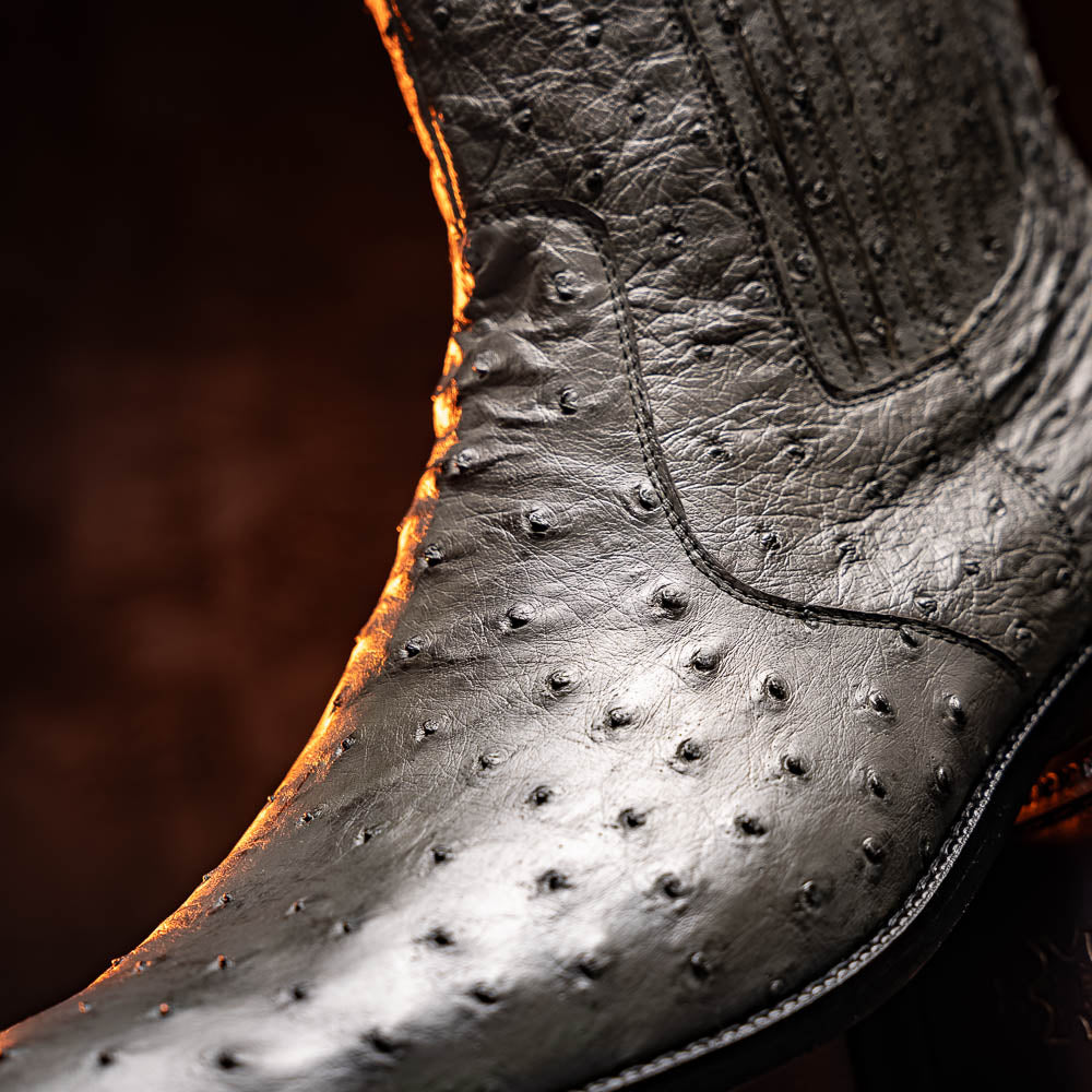 The Giorgio Serpentine Gray boots by Marco Di Milano—crafted from genuine ostrich quill leather—feature one upright and one on its side to reveal the sole, highlighting luxurious materials and exceptional craftsmanship.