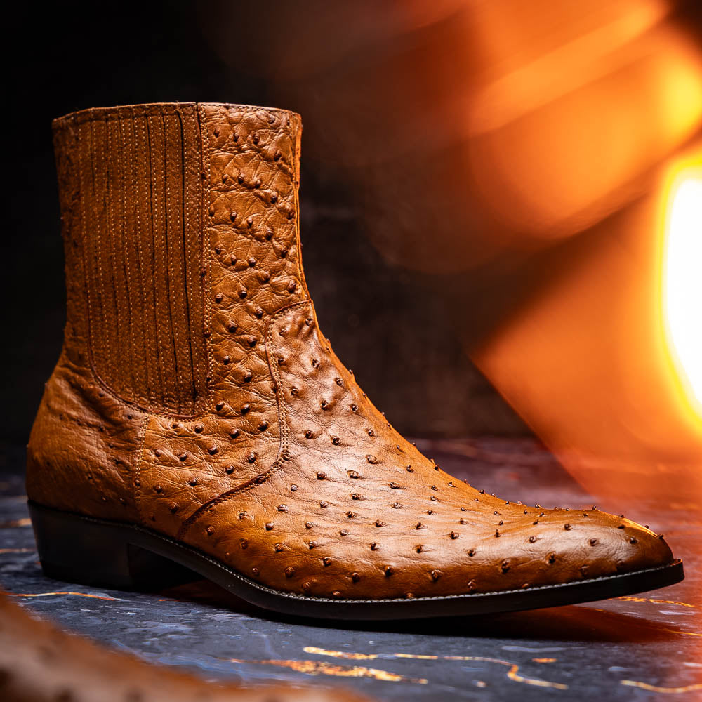 The Giorgio Brandy dress boots by Marco Di Milano feature genuine brown ostrich quill leather, hand-painted finishes, a side zipper, and a textured design—one upright and one lying down to showcase the sole's craftsmanship.