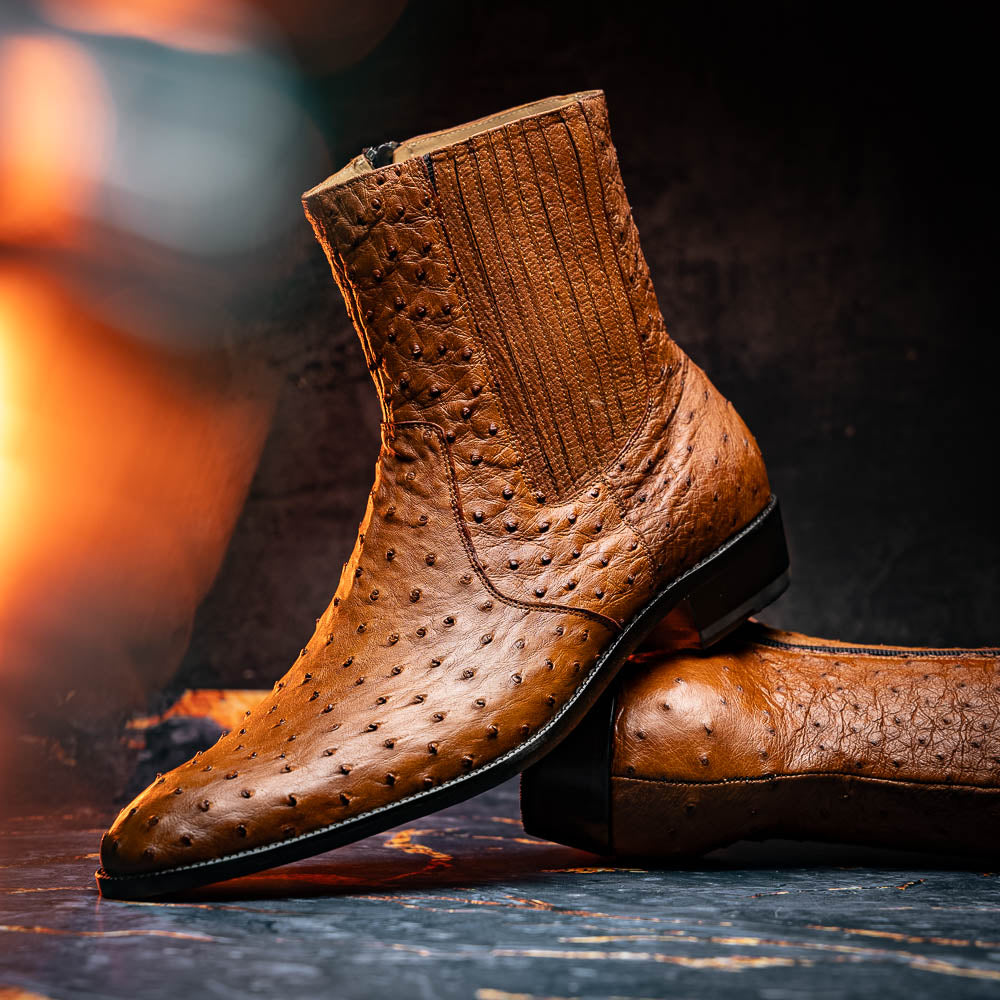 The Giorgio Brandy dress boots by Marco Di Milano feature genuine brown ostrich quill leather, hand-painted finishes, a side zipper, and a textured design—one upright and one lying down to showcase the sole's craftsmanship.