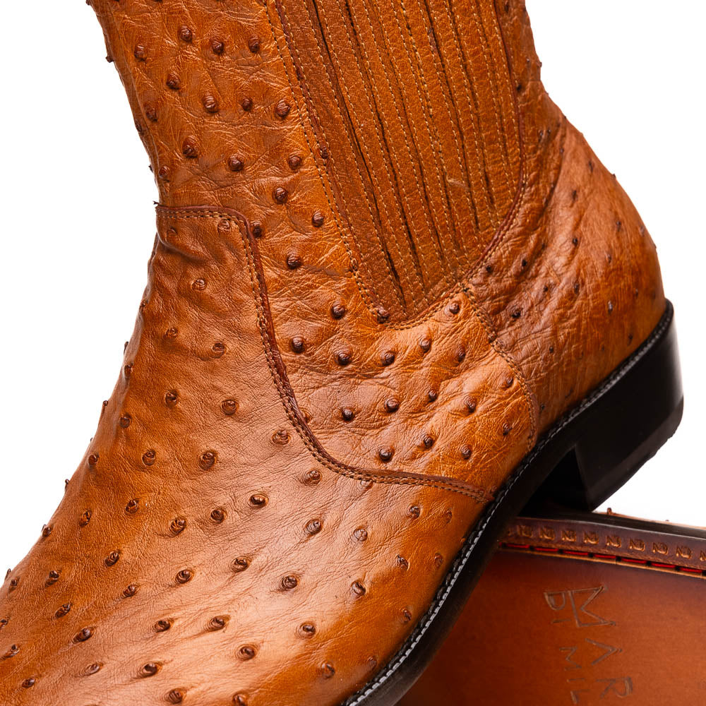 The Giorgio Brandy dress boots by Marco Di Milano feature genuine brown ostrich quill leather, hand-painted finishes, a side zipper, and a textured design—one upright and one lying down to showcase the sole's craftsmanship.