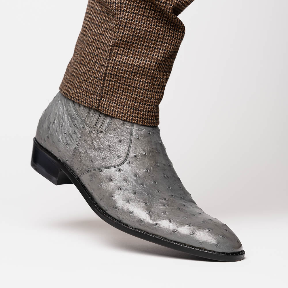 The Giorgio Serpentine Gray boots by Marco Di Milano—crafted from genuine ostrich quill leather—feature one upright and one on its side to reveal the sole, highlighting luxurious materials and exceptional craftsmanship.