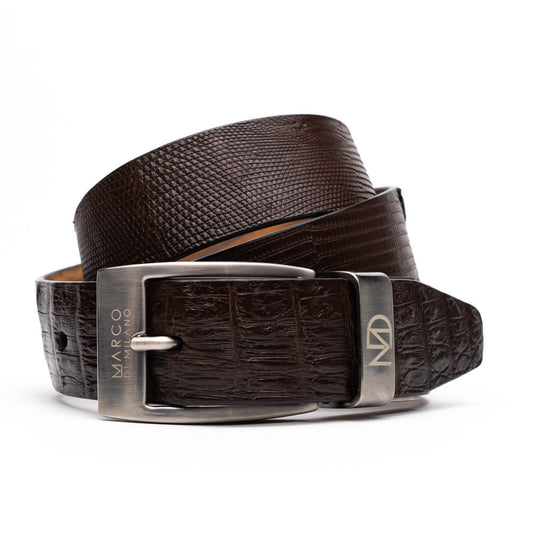 The Giovanni Belt Brown by Marco Di Milano is a dark brown leather belt with a textured pattern, finished with a silver buckle engraved with "Marco" and the "MD" logo, crafted from genuine lizard ring-caiman belly leather.