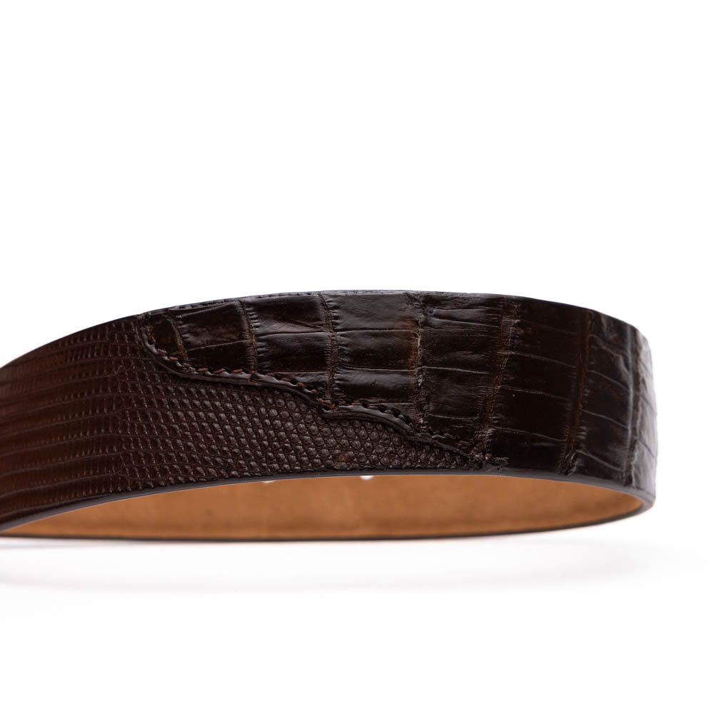The Giovanni Belt Brown by Marco Di Milano is a dark brown leather belt with a textured pattern, finished with a silver buckle engraved with "Marco" and the "MD" logo, crafted from genuine lizard ring-caiman belly leather.
