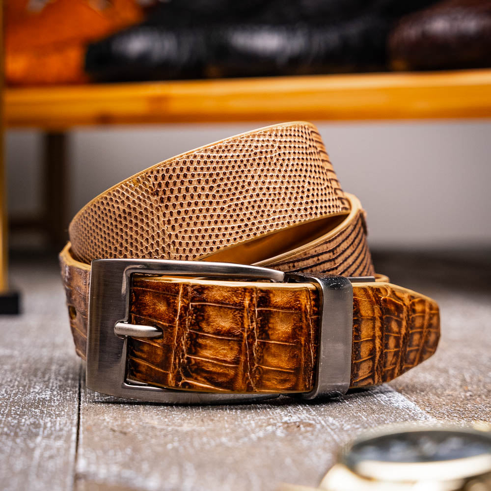 The Giovanni Belt Pantano Orix by Marco Di Milano is a brown leather belt with a silver buckle, showcasing crocodile embossing and a dotted design.