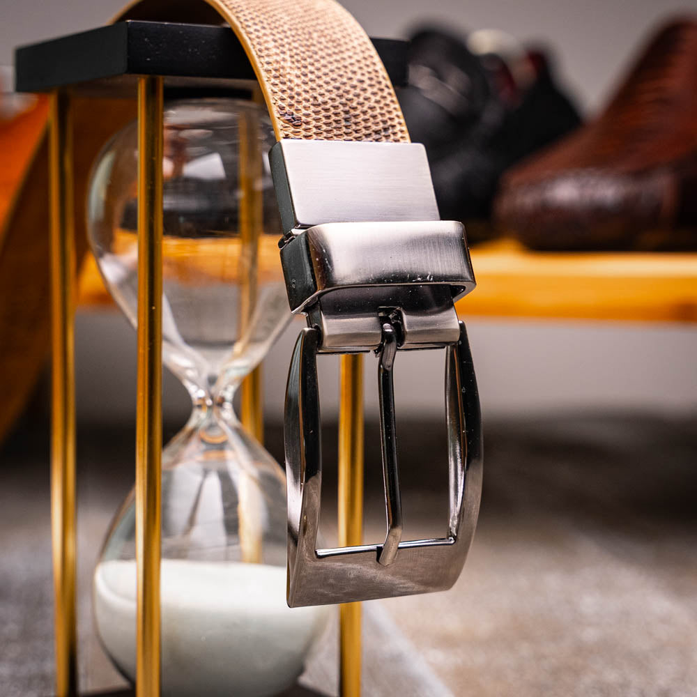 The Giovanni Belt Pantano Orix by Marco Di Milano is a brown leather belt with a silver buckle, showcasing crocodile embossing and a dotted design.